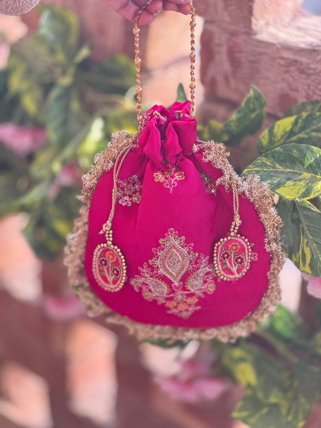 Rukhsaar: Hot Pink Silk Potli with Hand-Embroidered Gold Motifs & Fringe Border