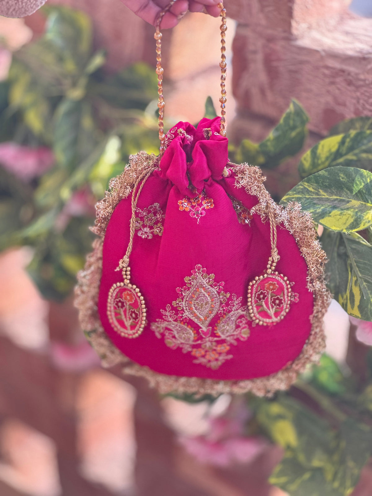 Rukhsaar: Hot Pink Silk Potli with Hand-Embroidered Gold Motifs & Fringe Border