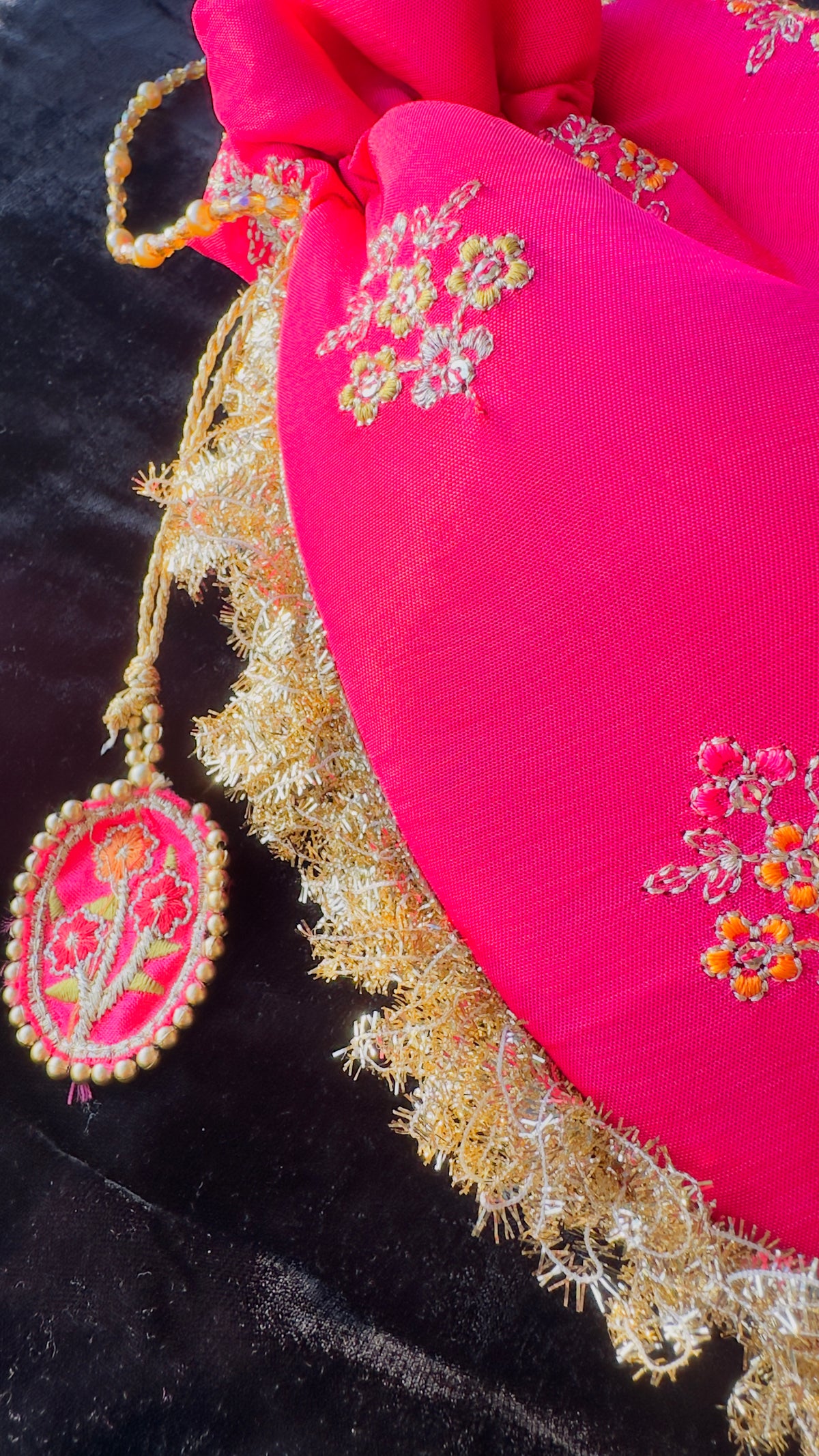 Rukhsaar: Hot Pink Silk Potli with Hand-Embroidered Gold Motifs & Fringe Border