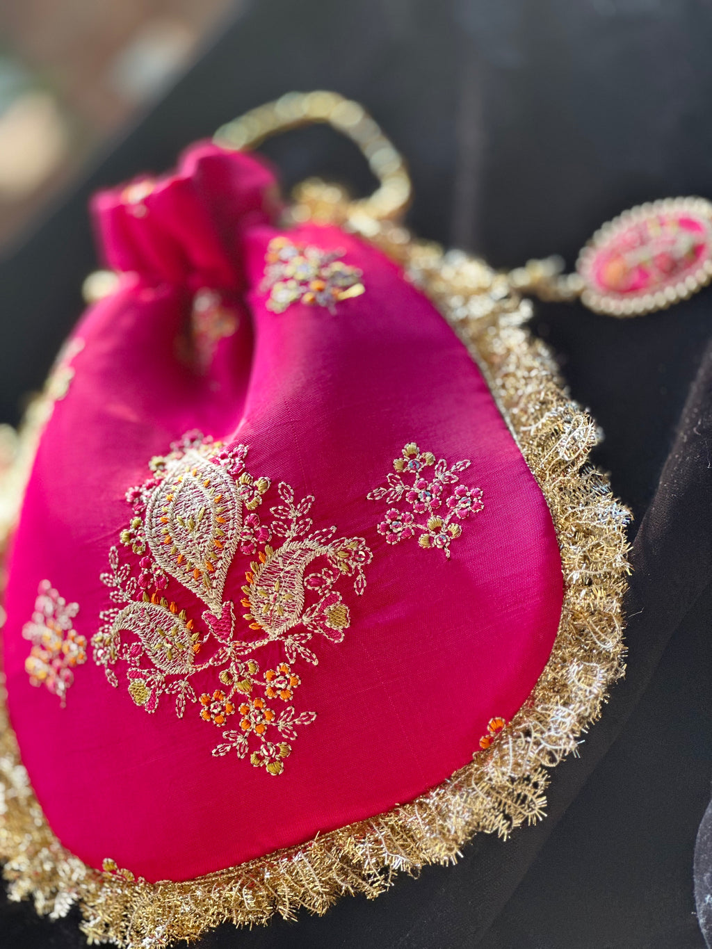 Rukhsaar: Hot Pink Silk Potli with Hand-Embroidered Gold Motifs & Fringe Border